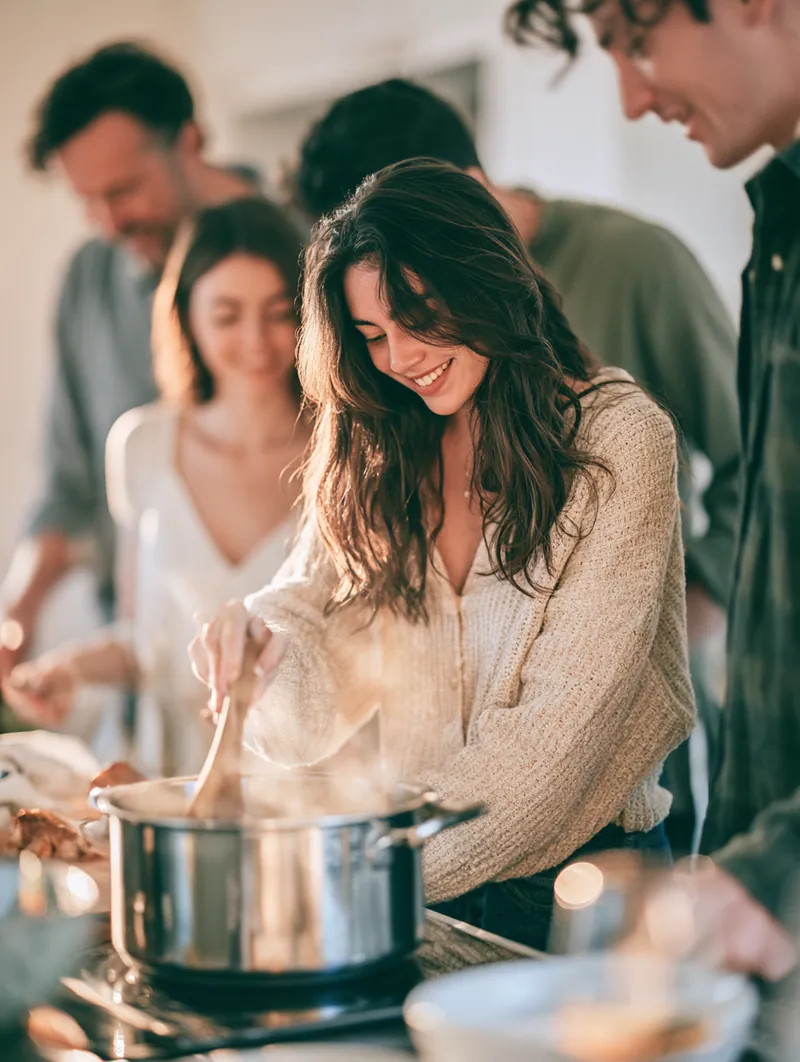 Family of four cooking dinner together in a bright kitchen
